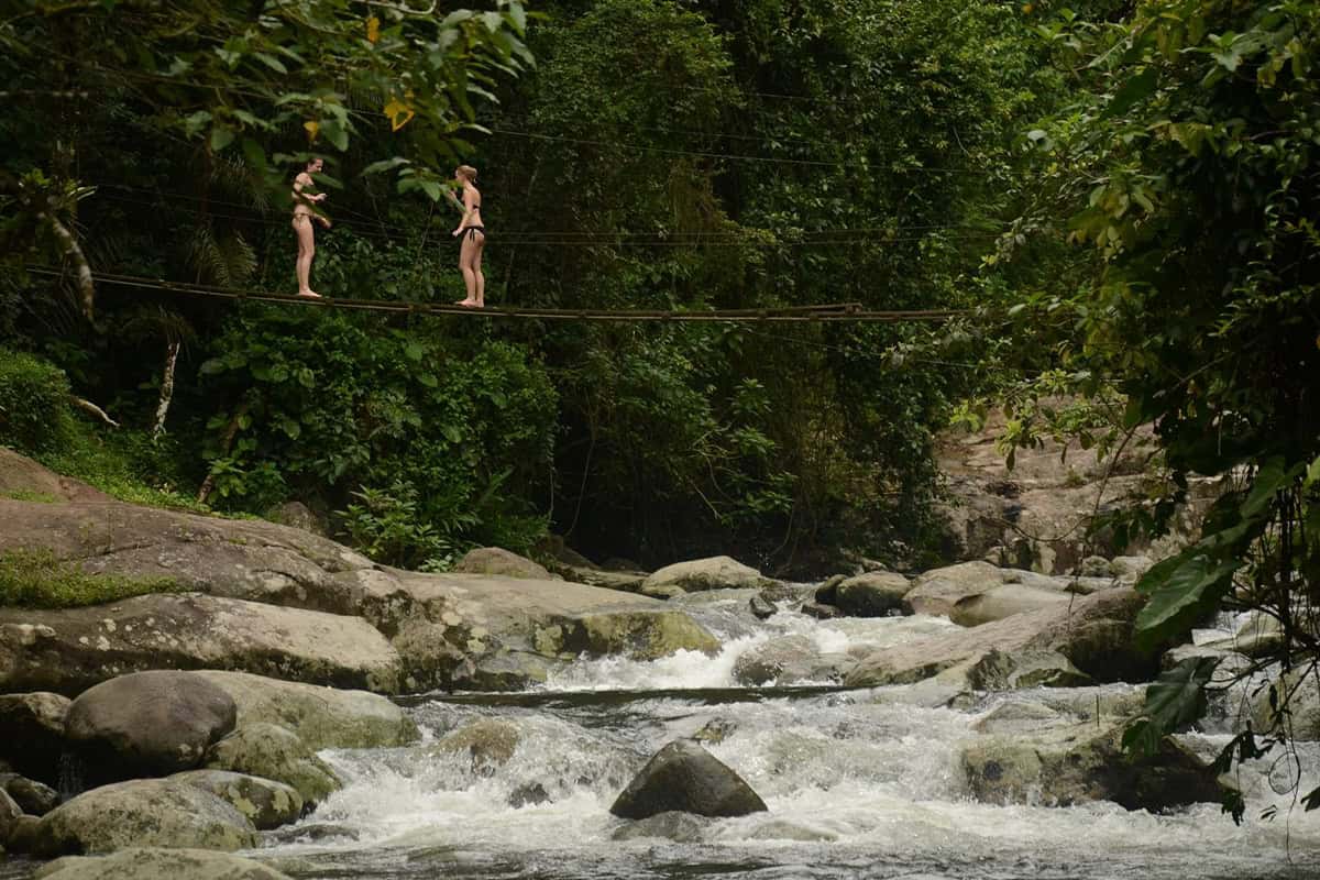 Poço do Tarzan em Paraty com ponte de madeira sobre o rio e piscina natural cercada por mata